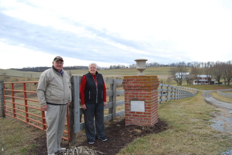 Don and Sue Hanger by the entrance gate to Berry-Moore Farm